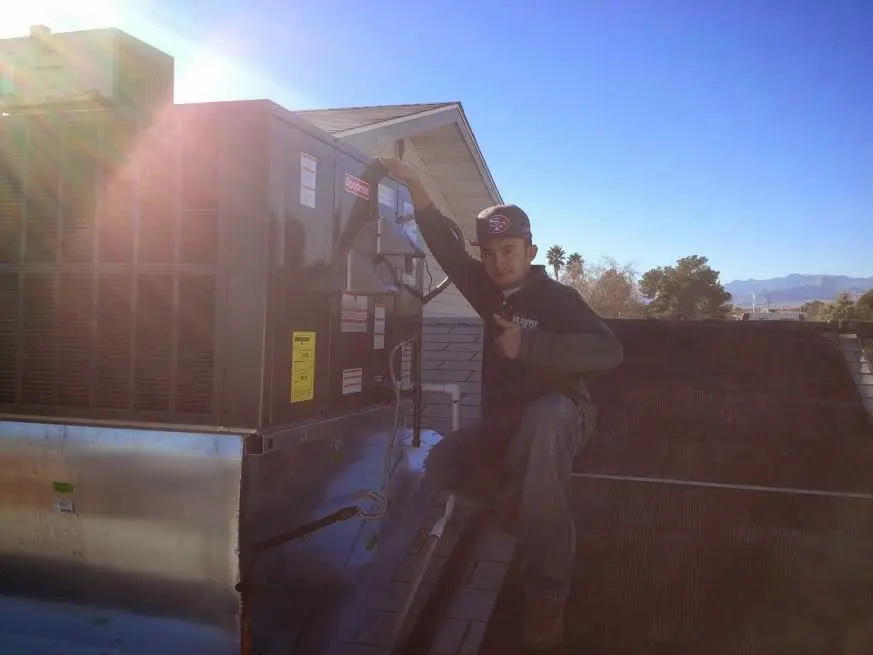 HVAC technician performing AC Tune-Up on a rooftop unit in Catalina